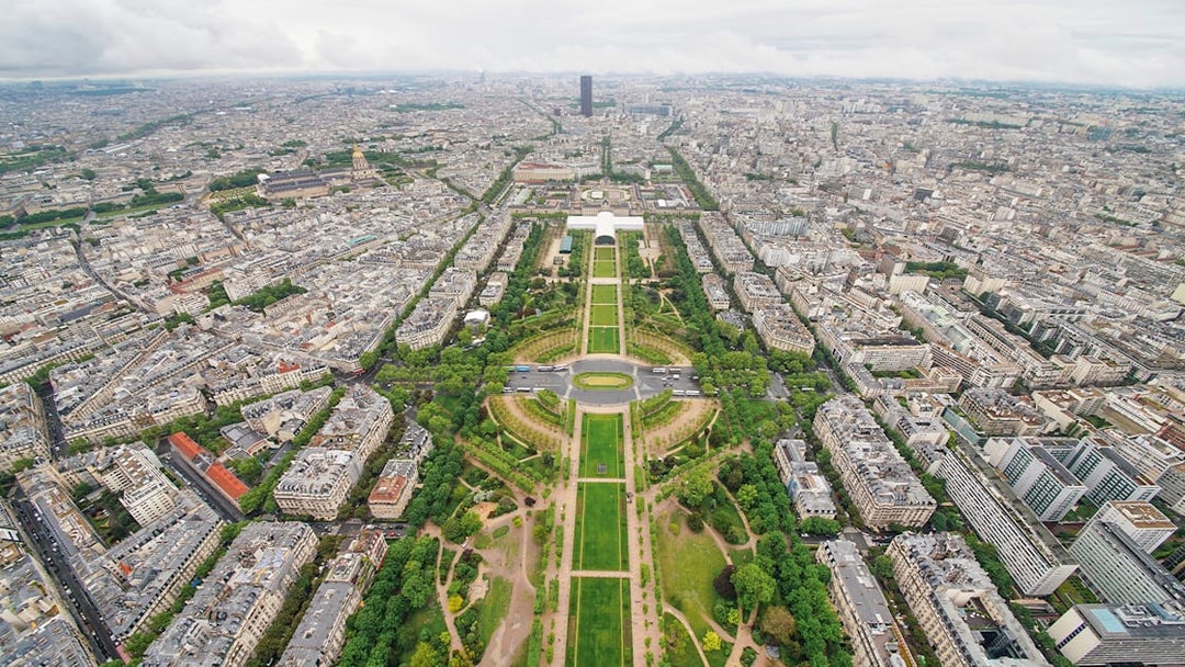 Aerial view of Paris from the Eiffel Tower, showcasing the Champ de Mars and cityscape.