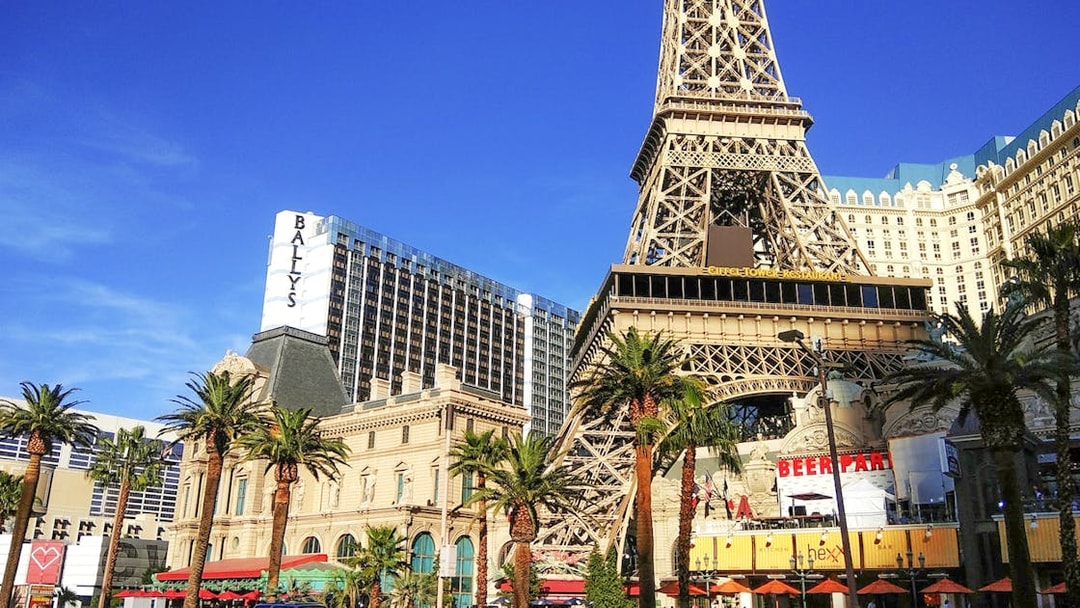 Eiffel Tower replica in Las Vegas with nearby hotels and palm trees.