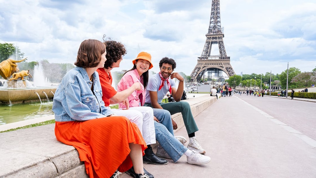 Participants sitting near Eiffel Tower during Paris city tour.
