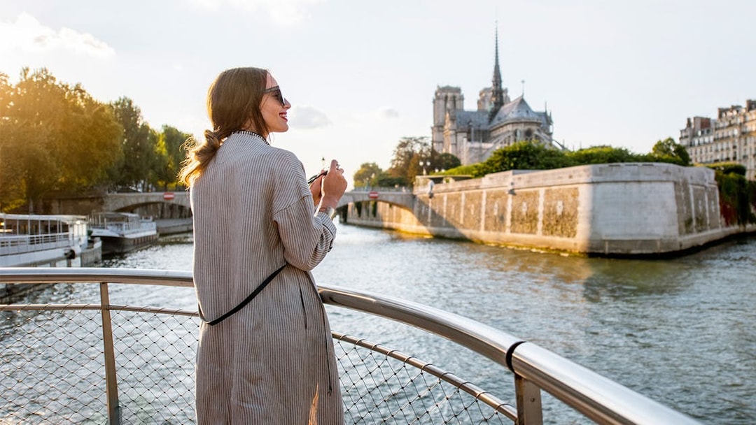 Participant enjoying Seine River Cruise with Notre-Dame Cathedral in Paris.