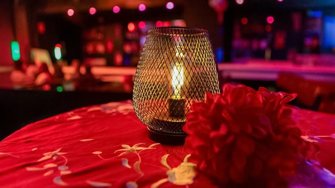 Candlelit table with red flowers at El Duende by Tablao Cordobes Flamenco Show.