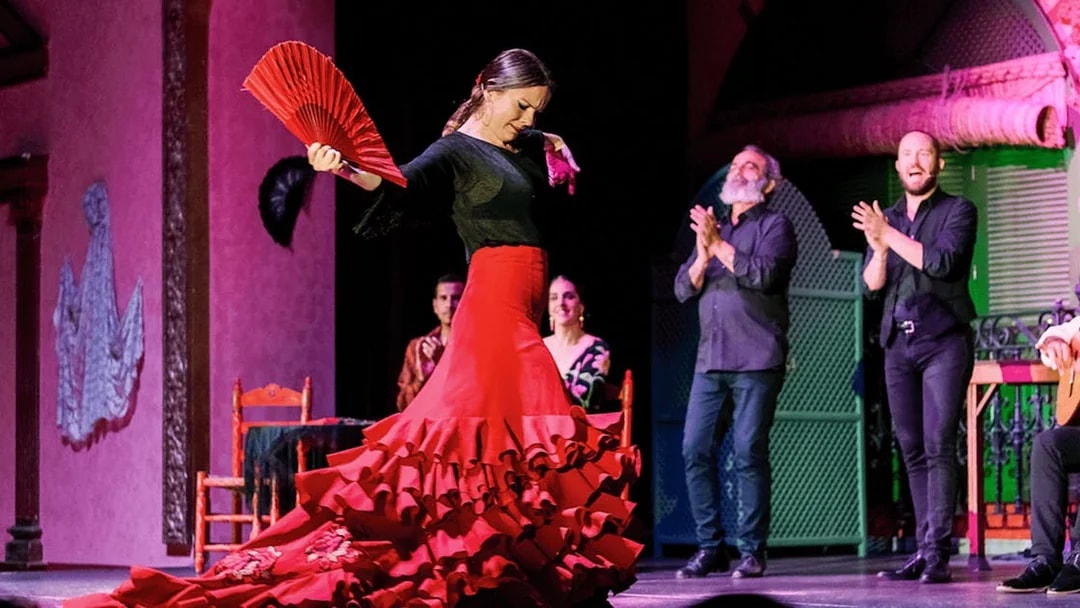 Flamenco dancer performing with a red fan at Only Flamenco, Seville.