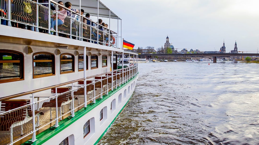 Sightseeing cruise on the Elbe River with Dresden skyline in the background.