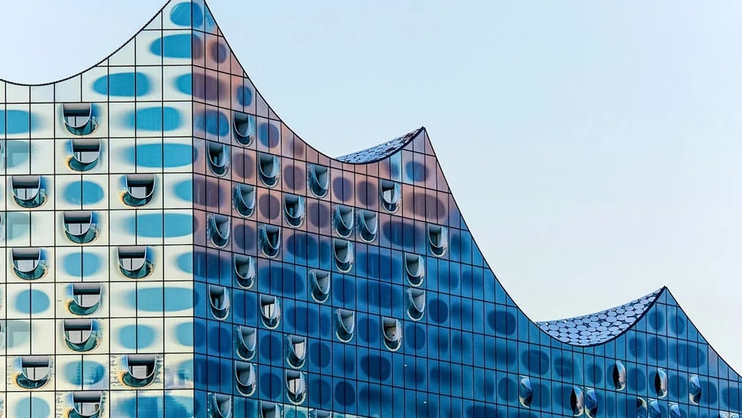 Elbphilharmonie's glass facade with wave-like roof design in Hamburg.