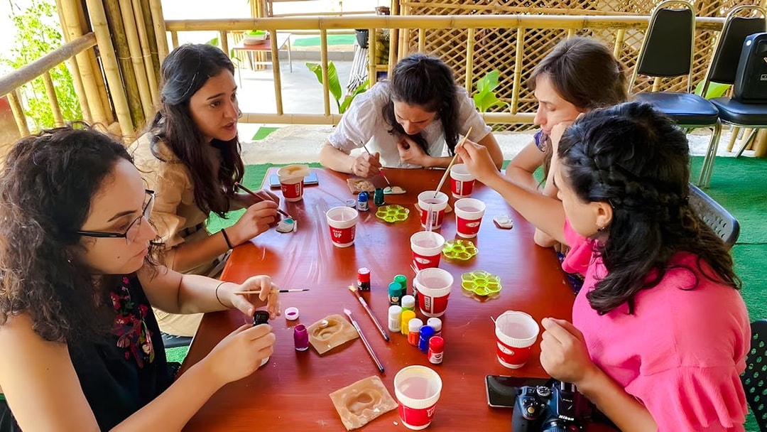 Group painting elephant miniatures at Phuket Elephant Care workshop.