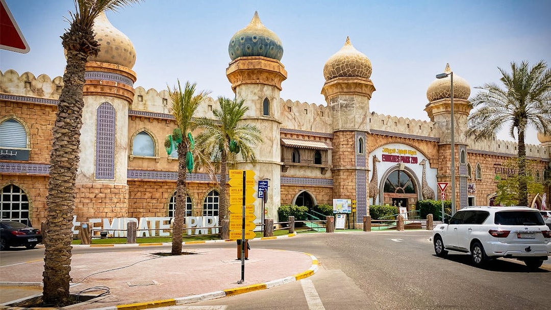 Entrance of Emirates Park Zoo with domed architecture and palm trees in Abu Dhabi.