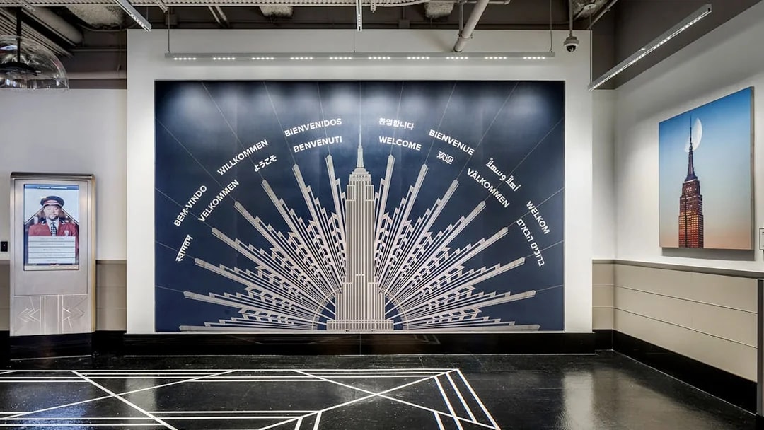 Empire State Building welcome mural with greetings in multiple languages.