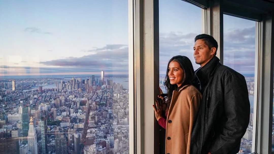 Couple enjoying New York City skyline view from Empire State Building Observatory.