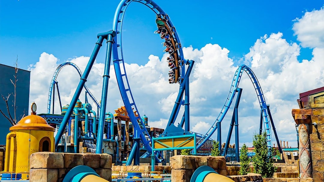 Roller coaster loop at Energylandia Amusement Park under a blue sky.