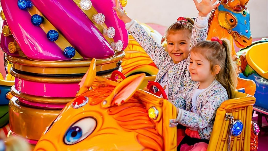 Children enjoying a colorful ride at Energylandia amusement park.
