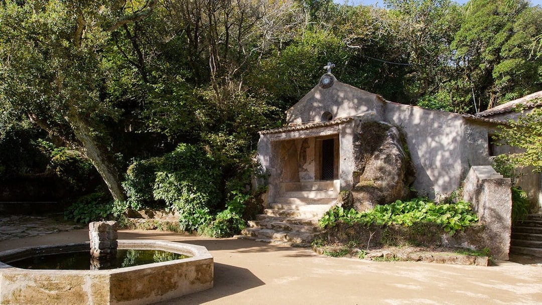 Convento dos Capuchos entrance surrounded by lush greenery in Sintra, Portugal.