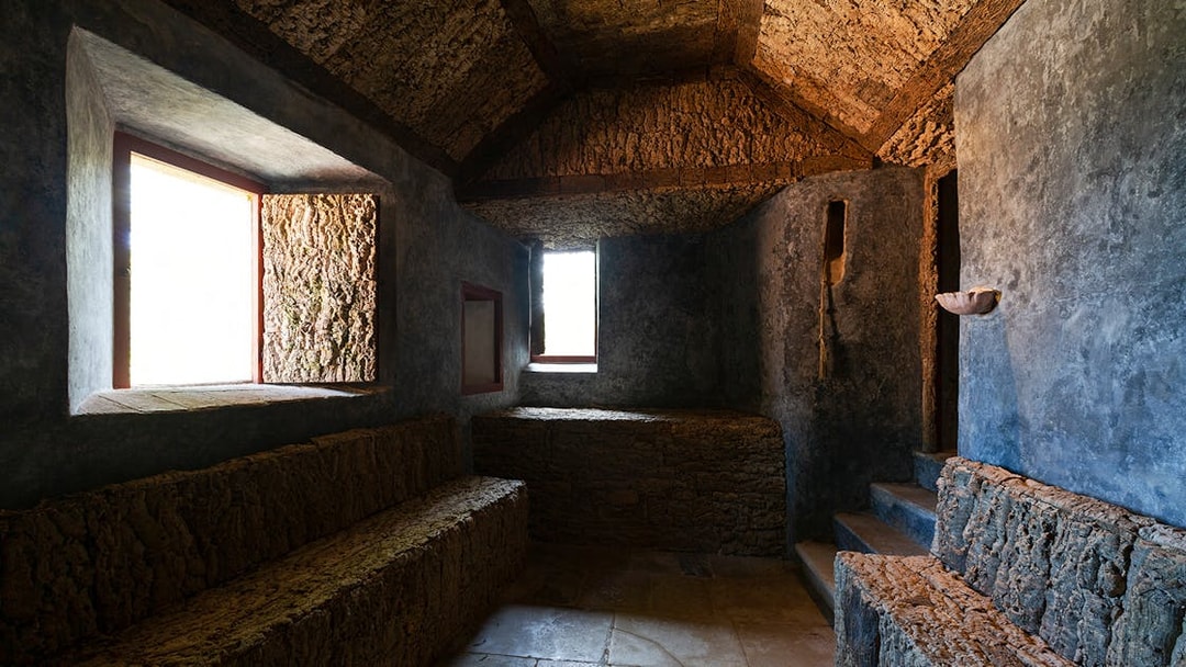 Convento dos Capuchos interior with stone benches and rustic walls, Sintra, Portugal.