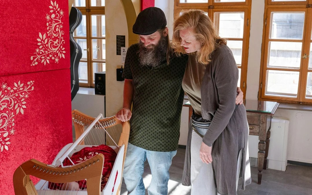 Guests exploring a harp exhibit at Mozart Interactive Museum, Prague.