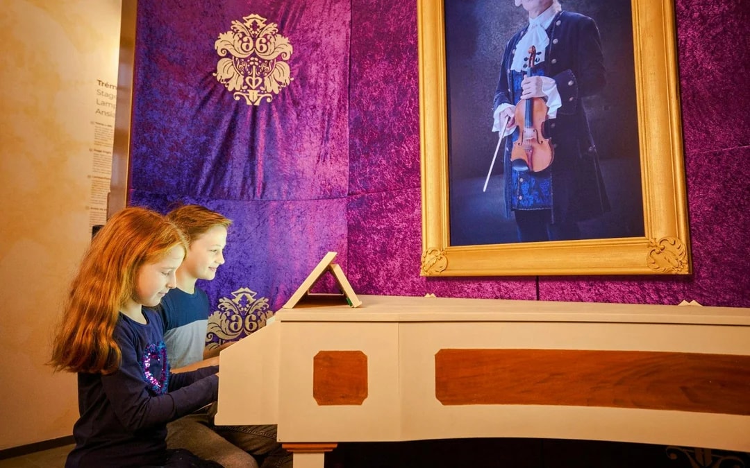 Guests playing piano at Mozart Interactive Museum, Prague.