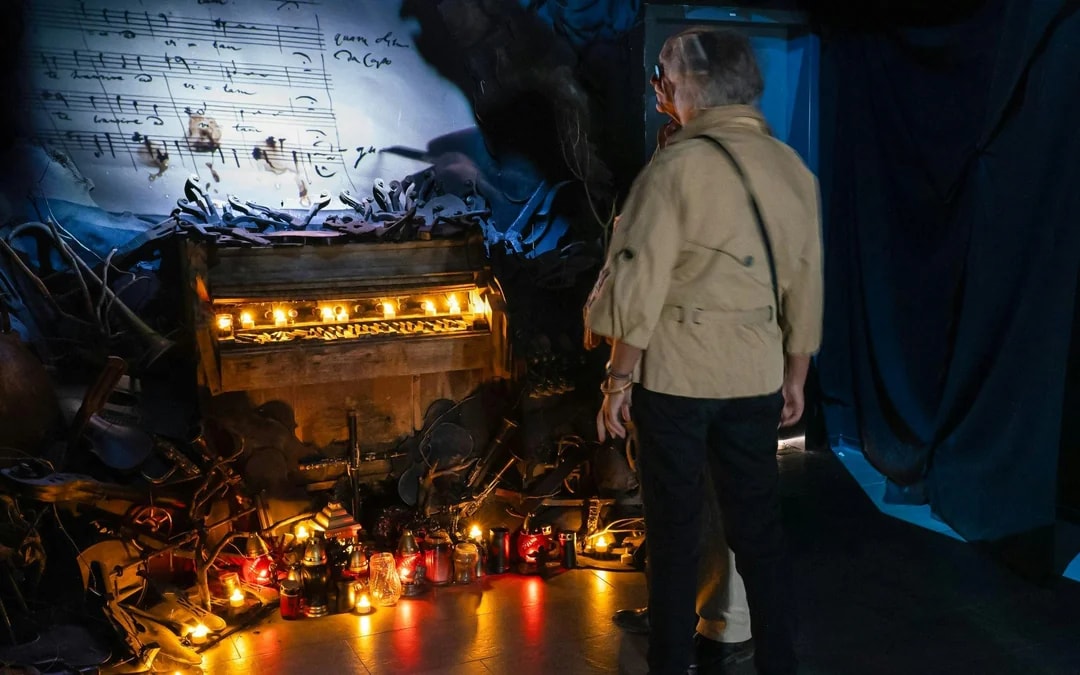 Guests exploring a candlelit piano exhibit at Mozart Interactive Museum, Prague.