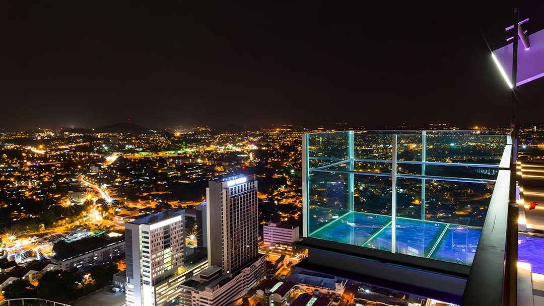 Sky deck view from The Shore Sky Tower at night, overlooking city lights in Melaka, Malaysia.