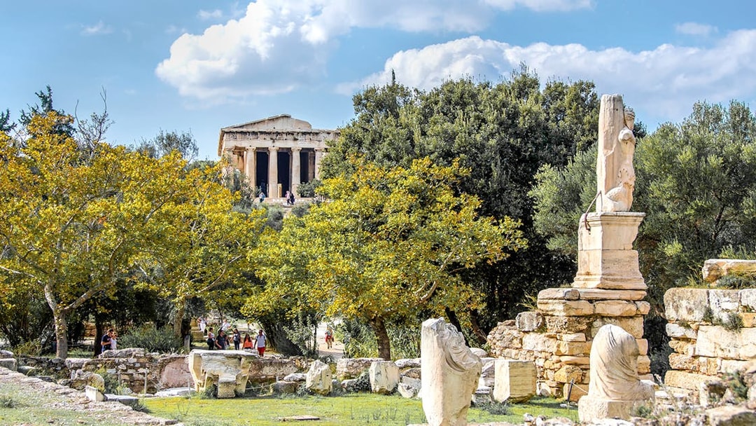 Ancient Agora of Athens with Temple of Hephaestus and marble ruins in foreground.