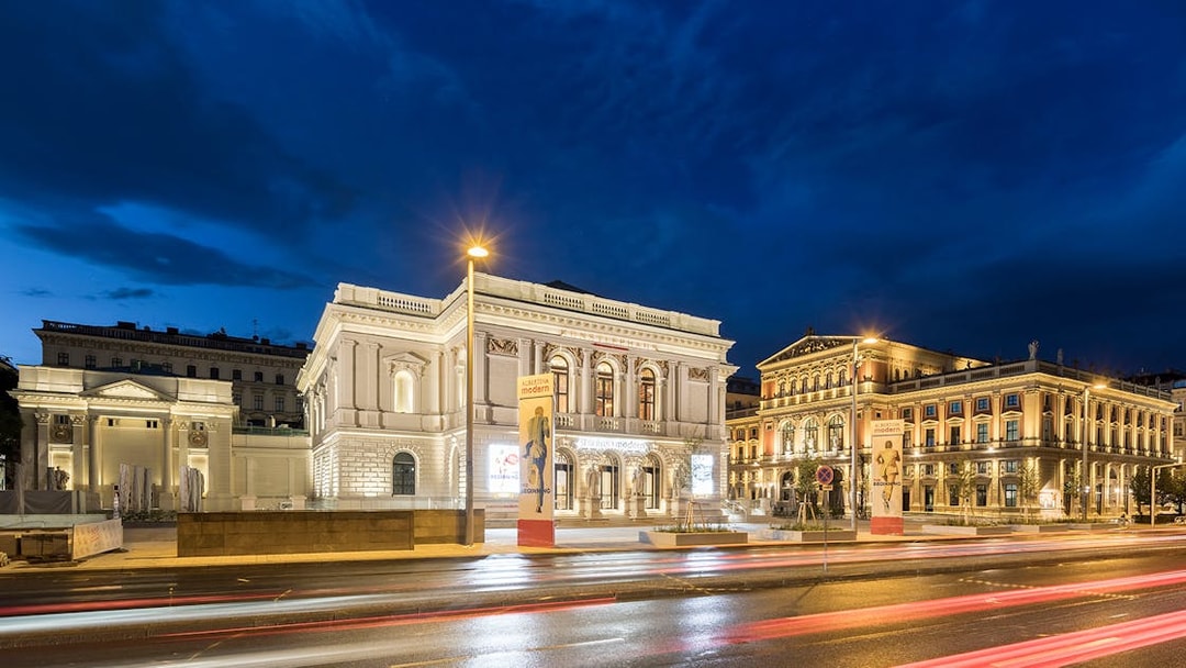 ALBERTINA MODERN museum in Vienna illuminated at night with street view.