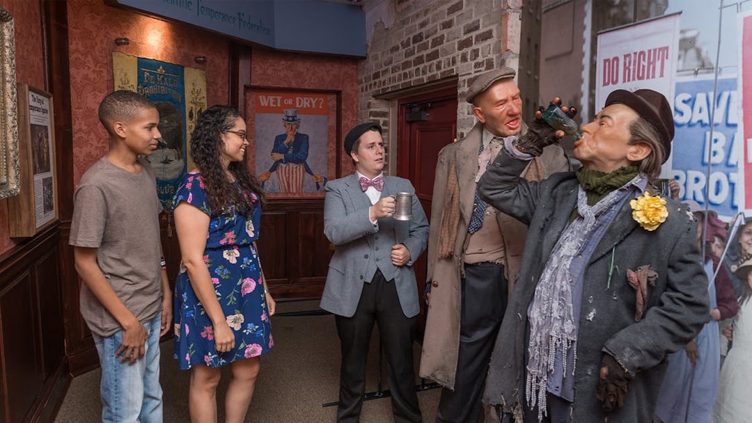 Visitors observing Prohibition-era figures at the American Prohibition Museum exhibit.