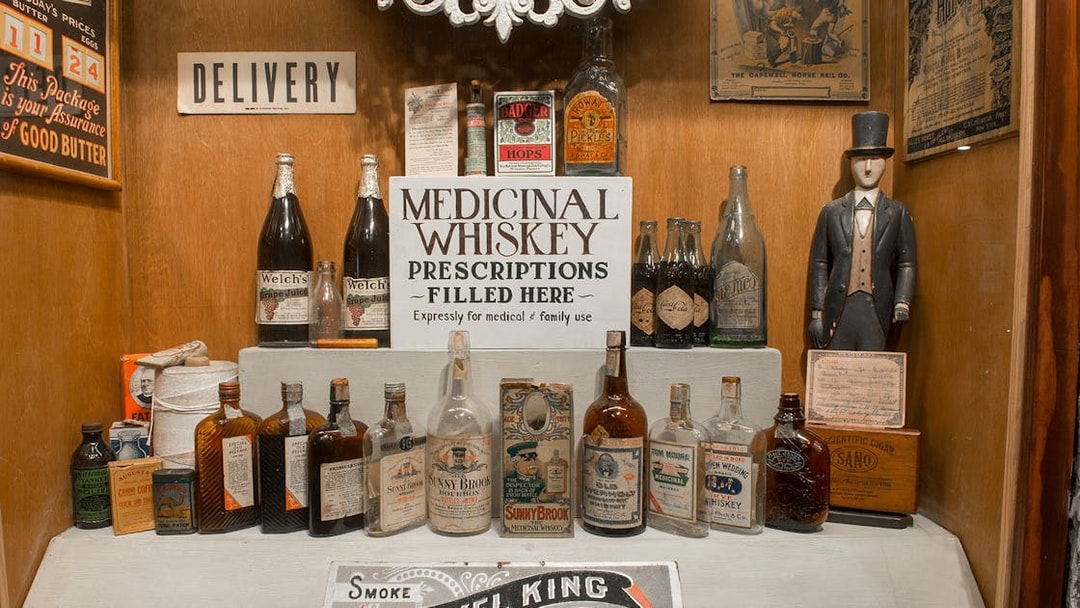 Medicinal whiskey display at American Prohibition Museum with vintage bottles and signage.