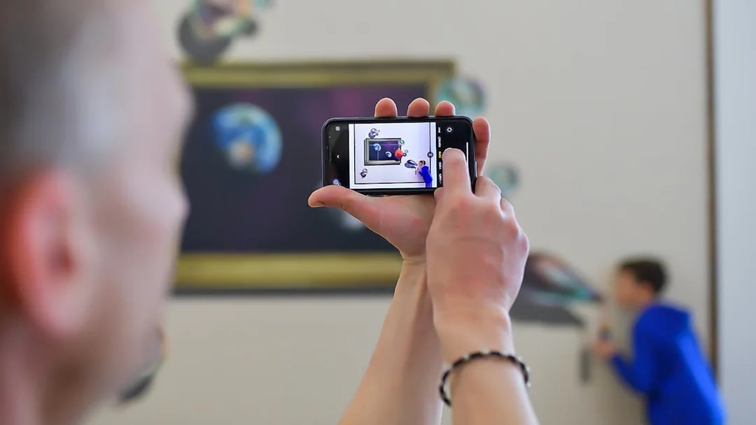 Person photographing illusion art at Illusion Art Museum Prague.