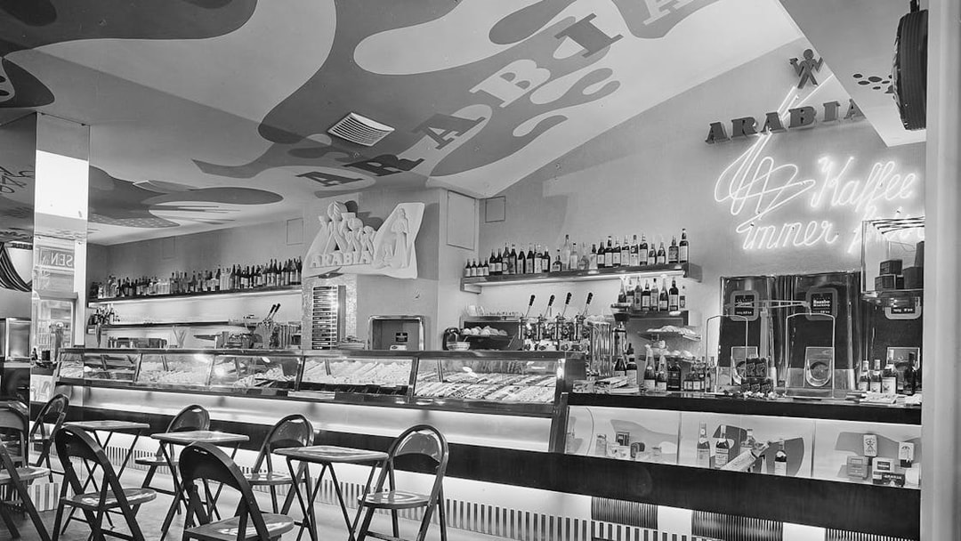 Bar area with chairs and neon sign at Jewish Museum Vienna.