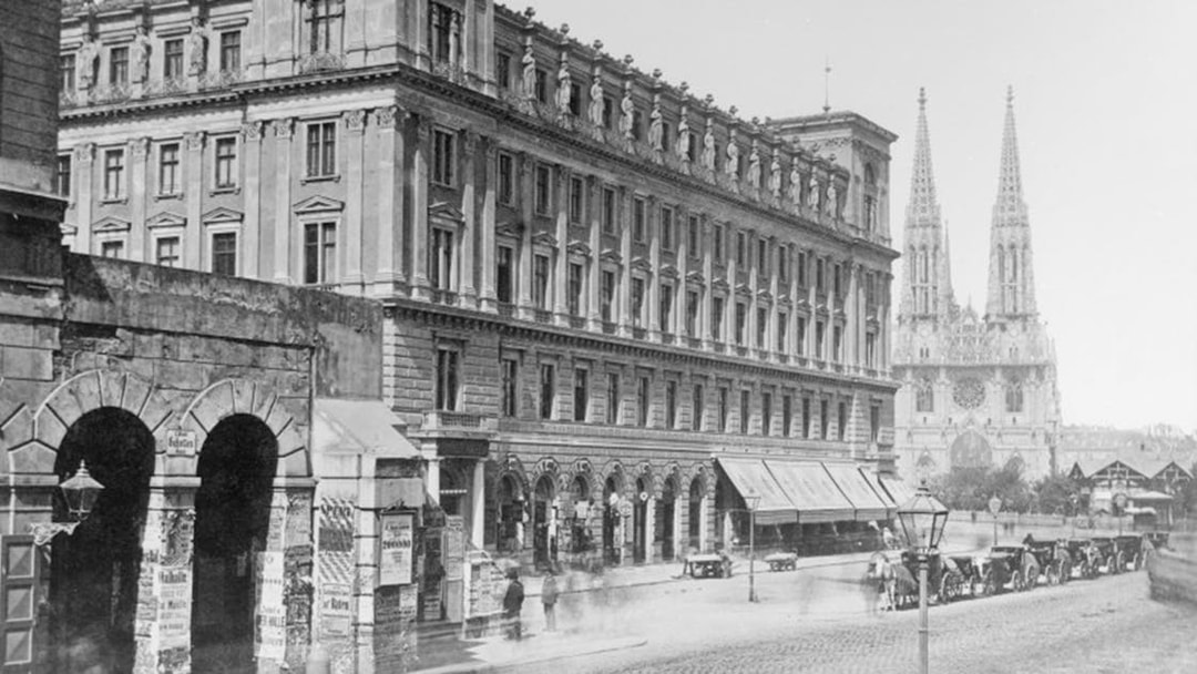 Historic street view near Jewish Museum Vienna with Votivkirche in the background.