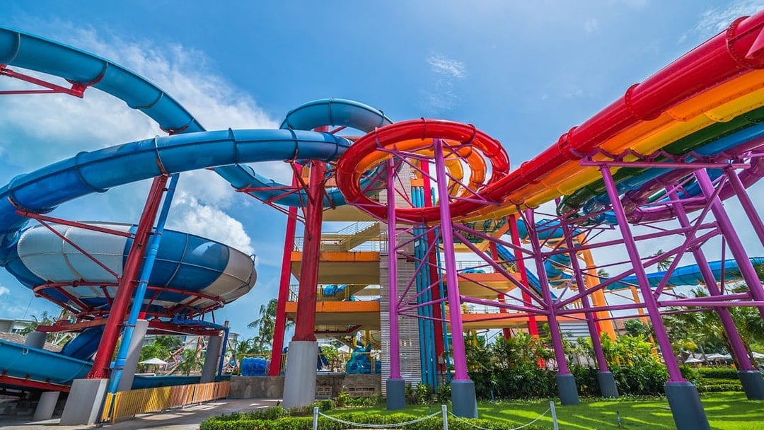 Colorful water slides at Splash Jungle Waterpark, featuring vibrant tubes and lush surroundings.