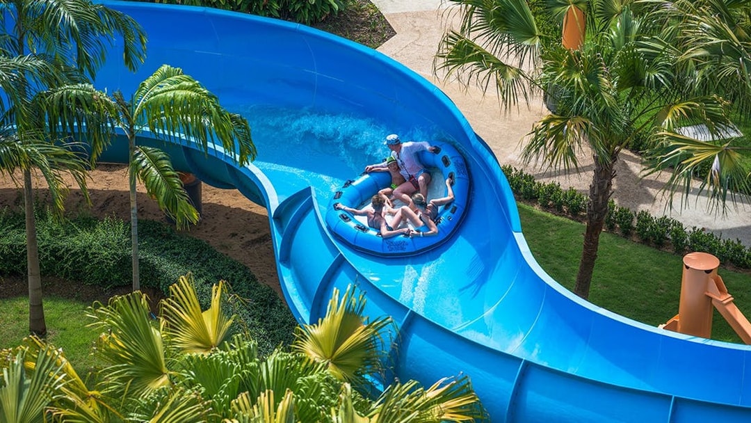 Group enjoying a raft ride on a blue water slide at Splash Jungle Waterpark.