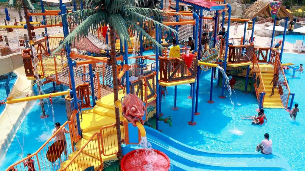 Children playing on colorful water slides and structures at Splash Jungle Waterpark.