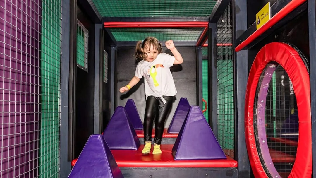 Child navigating obstacle course at SuperPark Malaysia.
