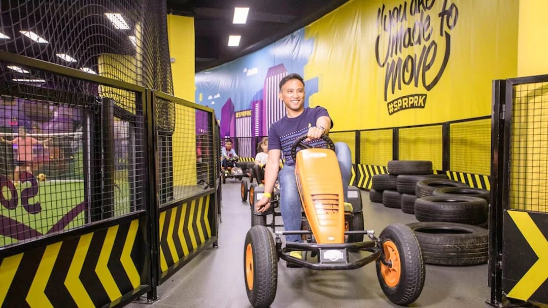 Man driving go-kart at Super Park, Malaysia indoor track.