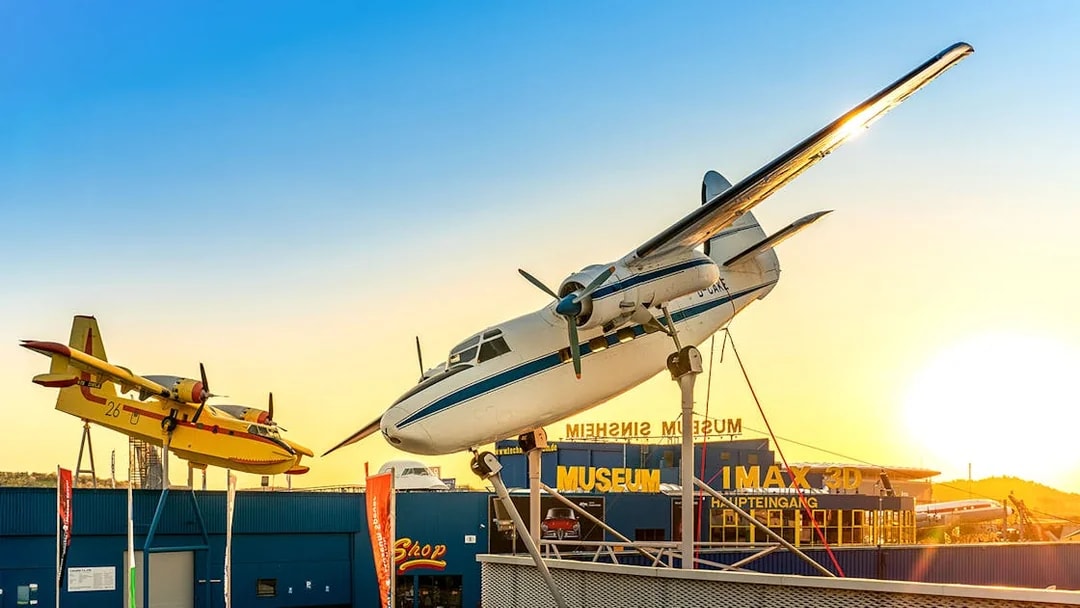 Aircraft display at Technik Museum Sinsheim with sunset backdrop.