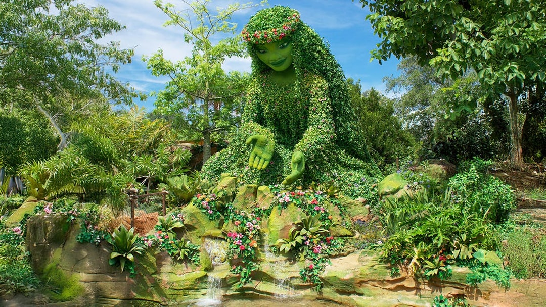 Giant green sculpture inspired by Moana surrounded by lush plants at Walt Disney Resort Orlando.