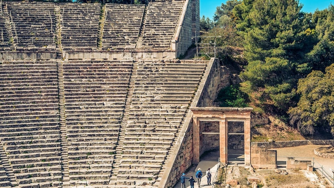 Epidaurus Ancient Theatre stone seating and entrance with visitors exploring.