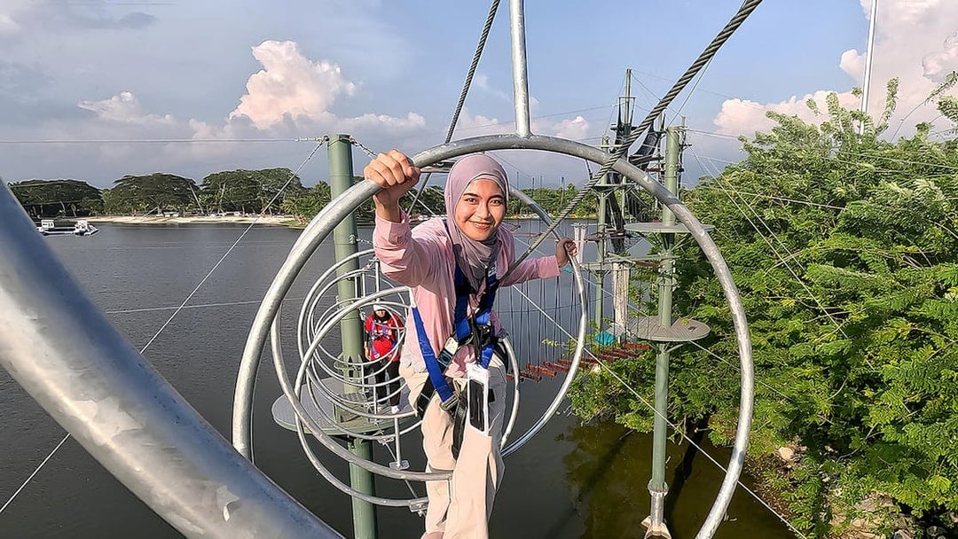 Person navigating a rope obstacle course at ESCAPE Ipoh Theme Park, Malaysia.