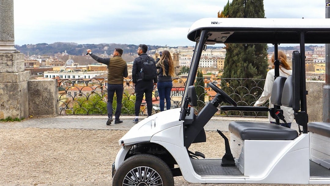 Golf cart parked with tourists overlooking Rome's skyline on the Eternal City Highlights Tour.