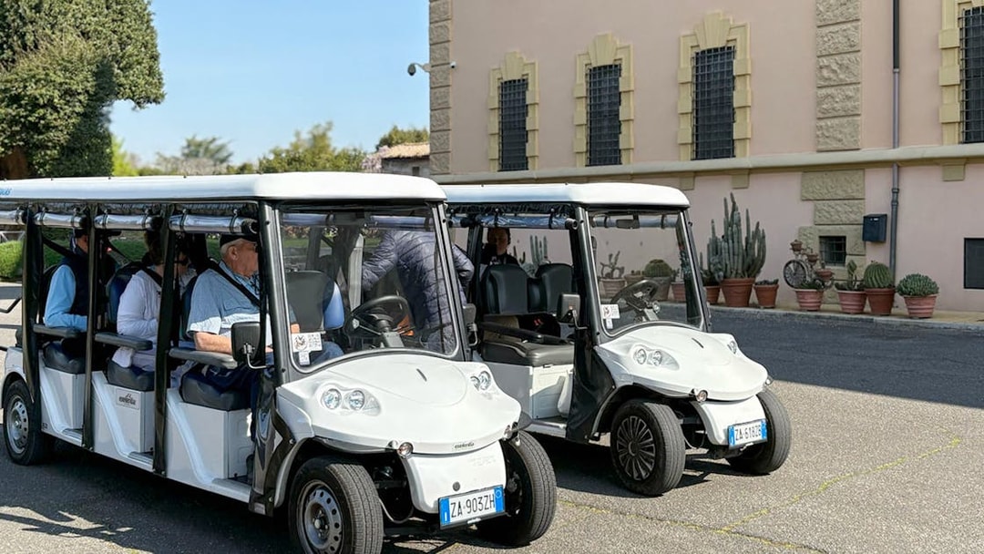 Golf carts parked outside a historic building in Rome during a tour.