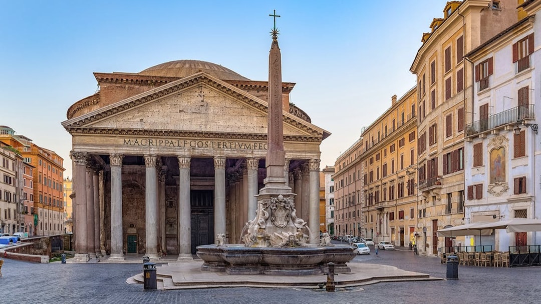 Pantheon in Rome with tourists exploring the ancient Roman temple and nearby fountain.