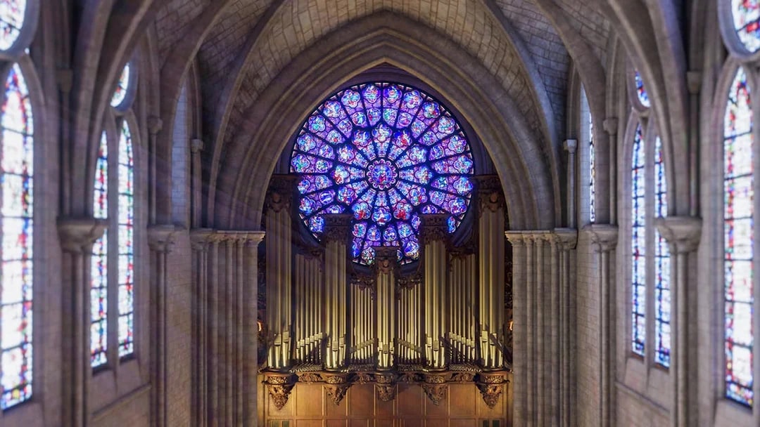 Stained glass rose window and organ inside Notre Dame Cathedral, Paris.