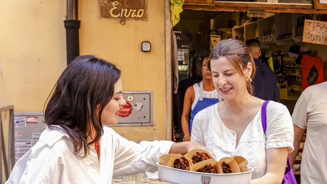 Woman enjoying Jewish-style artichoke at Da Enzo al 29 during Rome food tour.