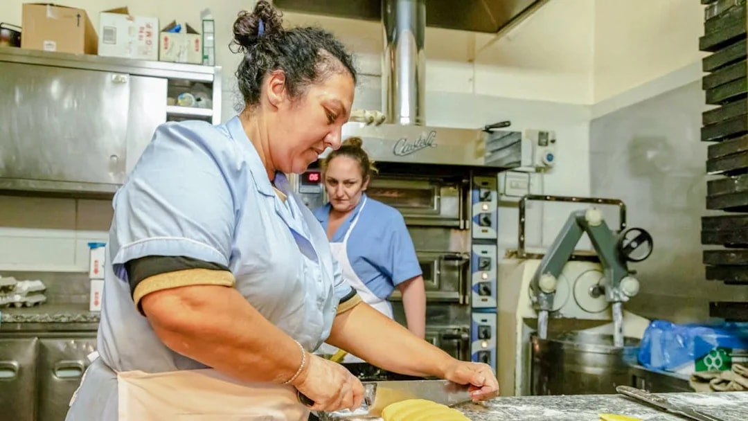 Woman preparing traditional Jewish-Roman cake in a historic bakery, Rome food tour.