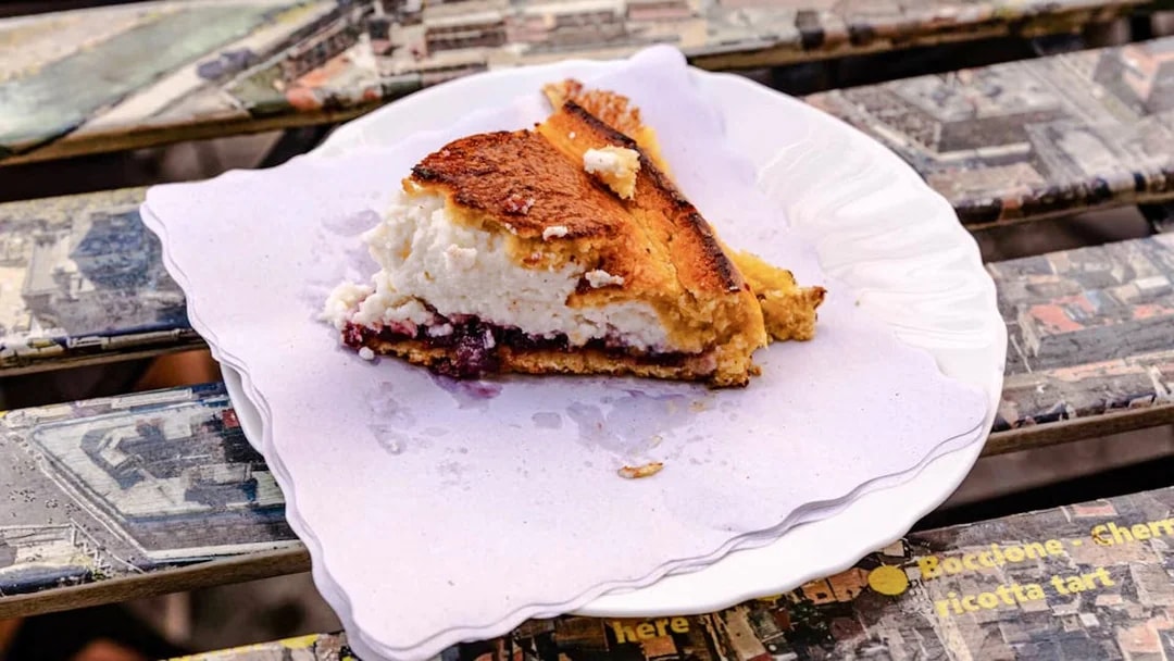 Boccone ricotta tart slice on a plate during a food tour in Rome's Campo de' Fiori.