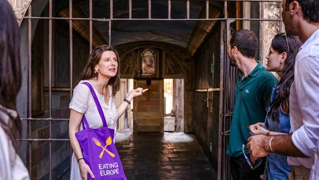Guide leading a group through a hidden passage on a Rome food tour.