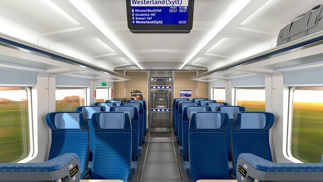 Interior of an Intercity train on the Eurail route in Germany, showing blue seats and overhead luggage space.