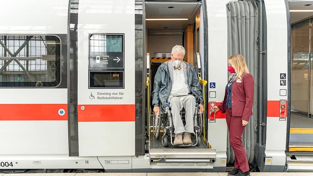 Wheelchair user assisted by staff on Eurail train in Germany.
