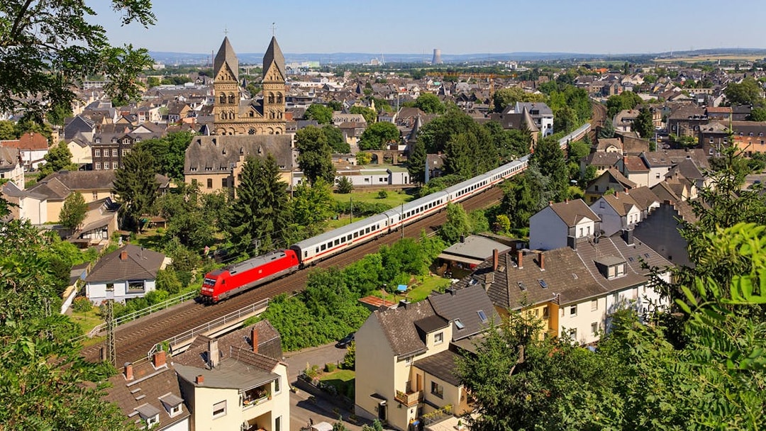 Intercity train passing through a German town with historic church in the background.