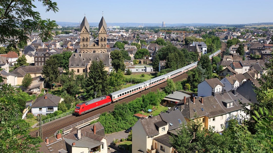 Euro Rail train passing through a German town with historic church in view.