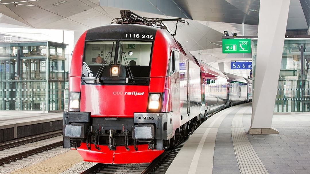 Red ÖBB Railjet train at a modern station platform, part of the Eurail Global Flexible Pass experience.
