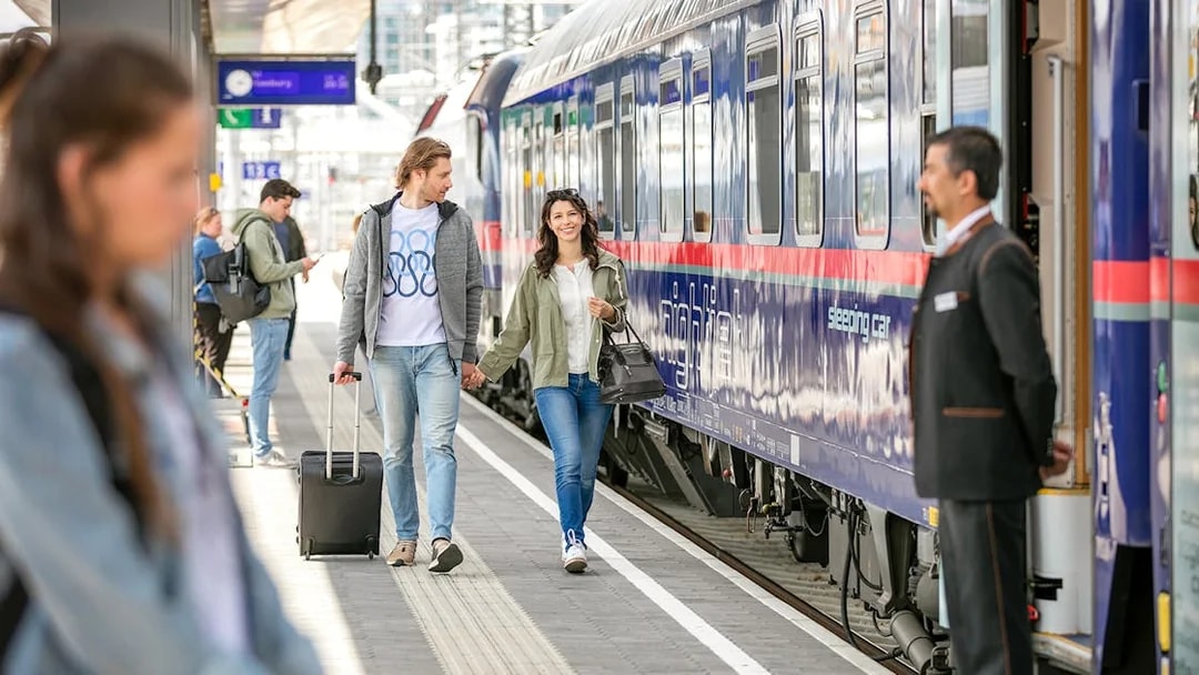 Couple boarding Eurail train at station platform.